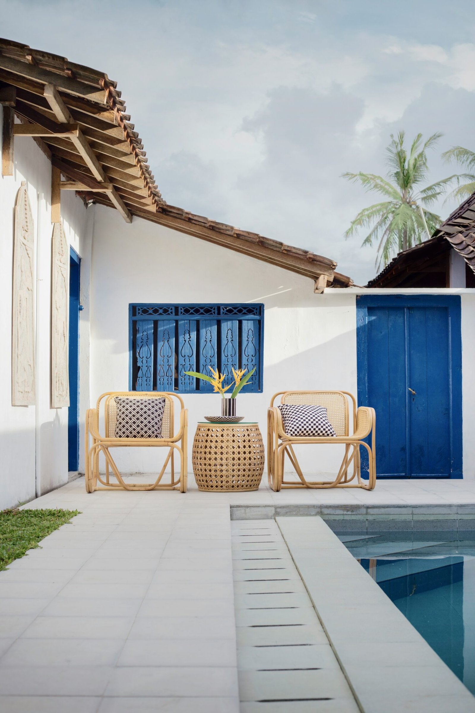 wicker table and two chairs near swimming pool